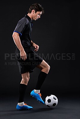Buy stock photo Skill, football and man for fitness in studio with recreational sports training isolated on black background. Training, freestyle and male athlete with control in soccer kit with juggling tricks.