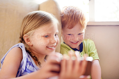 Buy stock photo Relax, siblings and children with smartphone, watching and smile for movies in home, sofa and online. House, fun and kids with mobile for entertainment, streaming or subscription for film in lounge