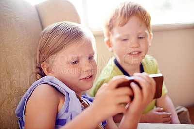 Buy stock photo Bonding, siblings and children with smartphone, watching and smile for movies in home, sofa or online. House, fun and kids with mobile for entertainment, streaming or subscription for film in lounge
