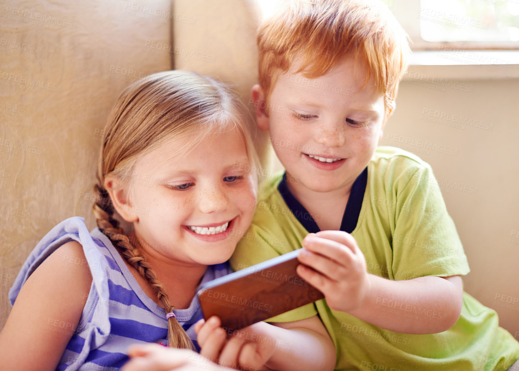 Buy stock photo Fun, siblings and children with smartphone, watching and smile for movies in home, sofa or online. House, relax and kids with mobile for entertainment, streaming or subscription for film in lounge