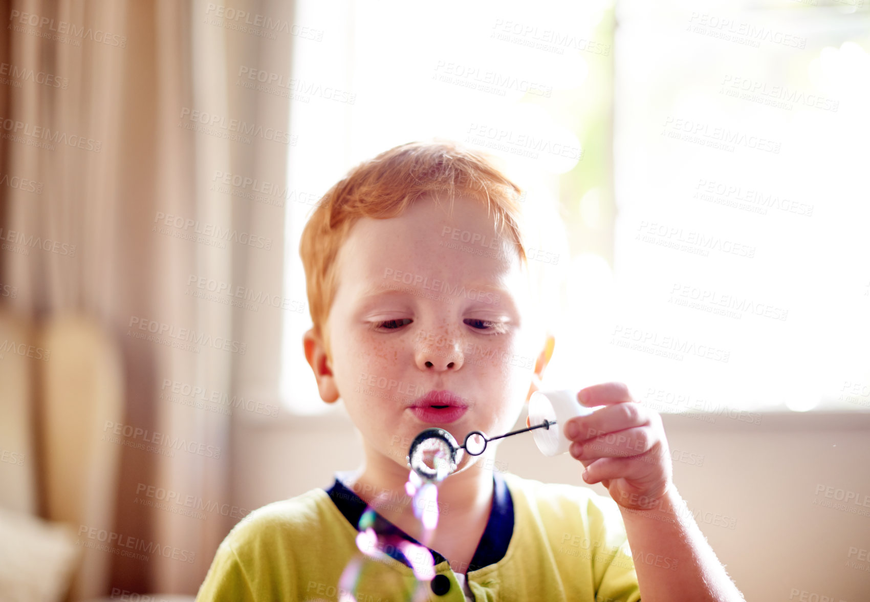 Buy stock photo Boy, child and blowing bubbles in home for sensory stimulation, cognitive development or entertainment. Growth, kid or wand with liquid soap for playing fun game, creative imagination or motor skills