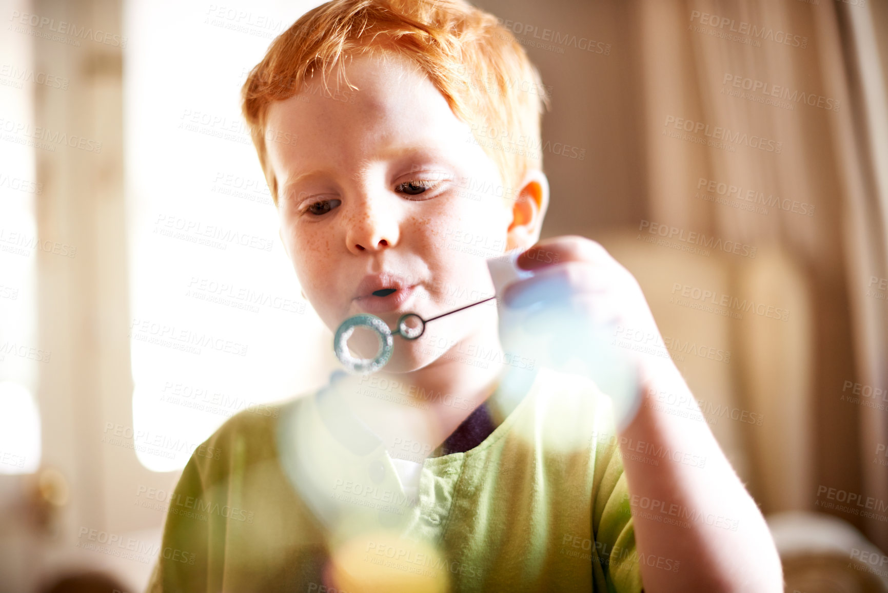 Buy stock photo Boy, kid and blowing bubbles in home for sensory stimulation, cognitive development and creative activity. Bokeh, child and wand with liquid soap for playing fun game, coordination and weekend break