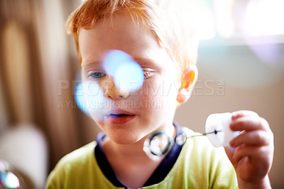 Buy stock photo Boy, kid and blowing bubbles with playing for sensory stimulation, child development and creative activity. Bokeh, person and wand with liquid soap for fun game, motor skills and curious imagination