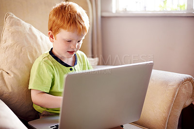 Buy stock photo Typing, serious and child with laptop, home and elearning for education of boy, growth and development. House, studying and knowledge for kid with assignment, online and tech for digital literacy