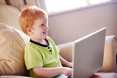 Buy stock photo Education, laptop and smile of happy boy on sofa in living room of home for learning or study. Computer, homework and knowledge with child student typing in apartment for development or growth