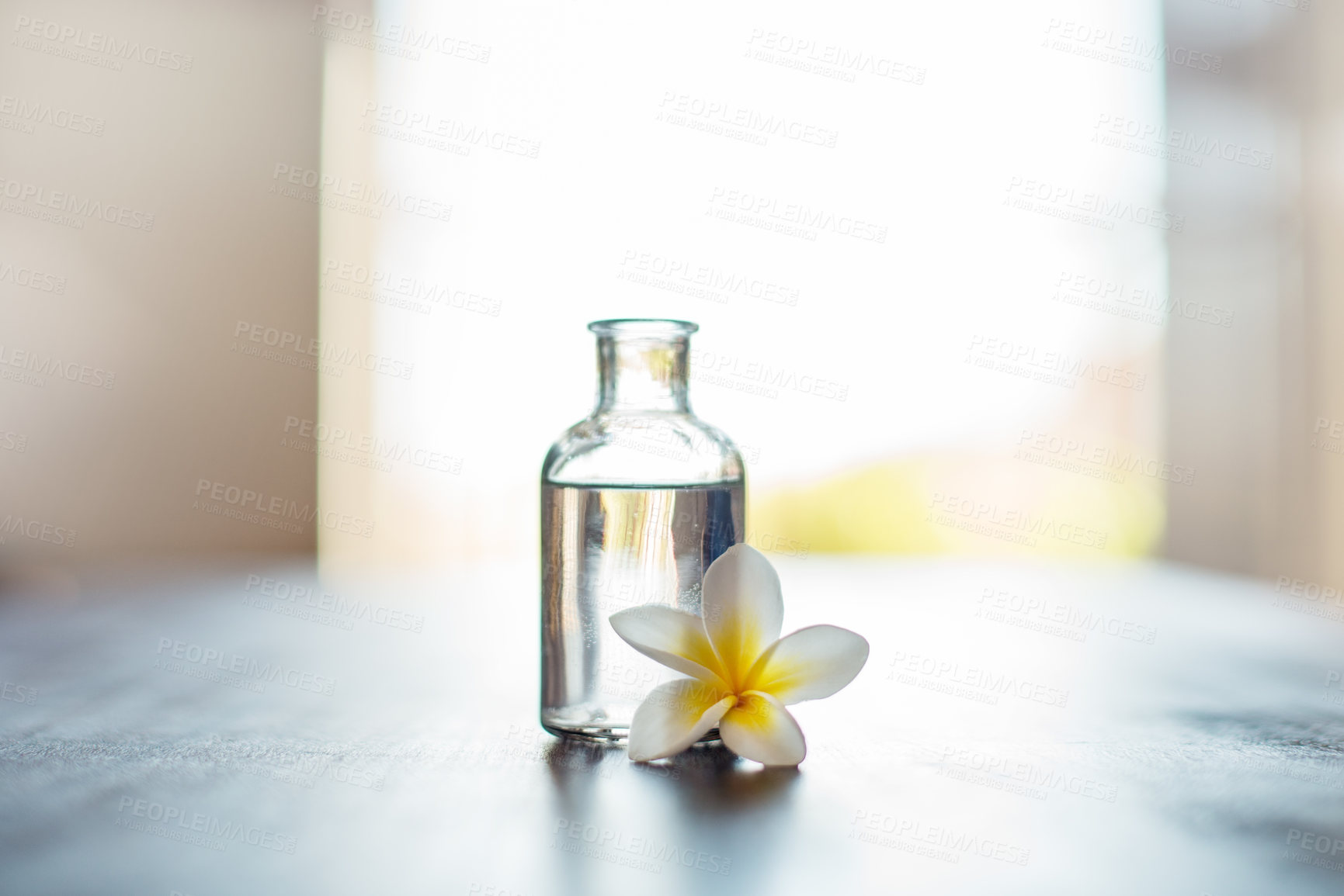 Buy stock photo Wellness, space and essential oil with flowers on table for skin health, stress relief and relaxation fragrance. Interior decor, cosmetics and beauty product for skincare, antioxidants and anti aging
