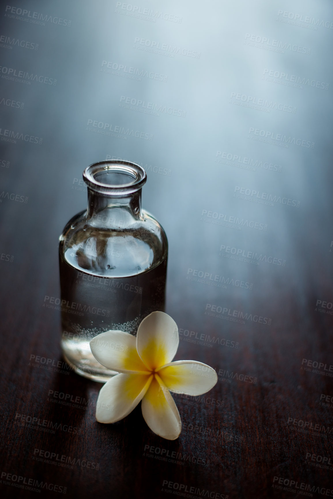 Buy stock photo Wellness, space and essential oil with flower on table for skin health, stress relief and aromatherapy massage. Above, interior mockup and organic product for skincare, antioxidants and spa treatment