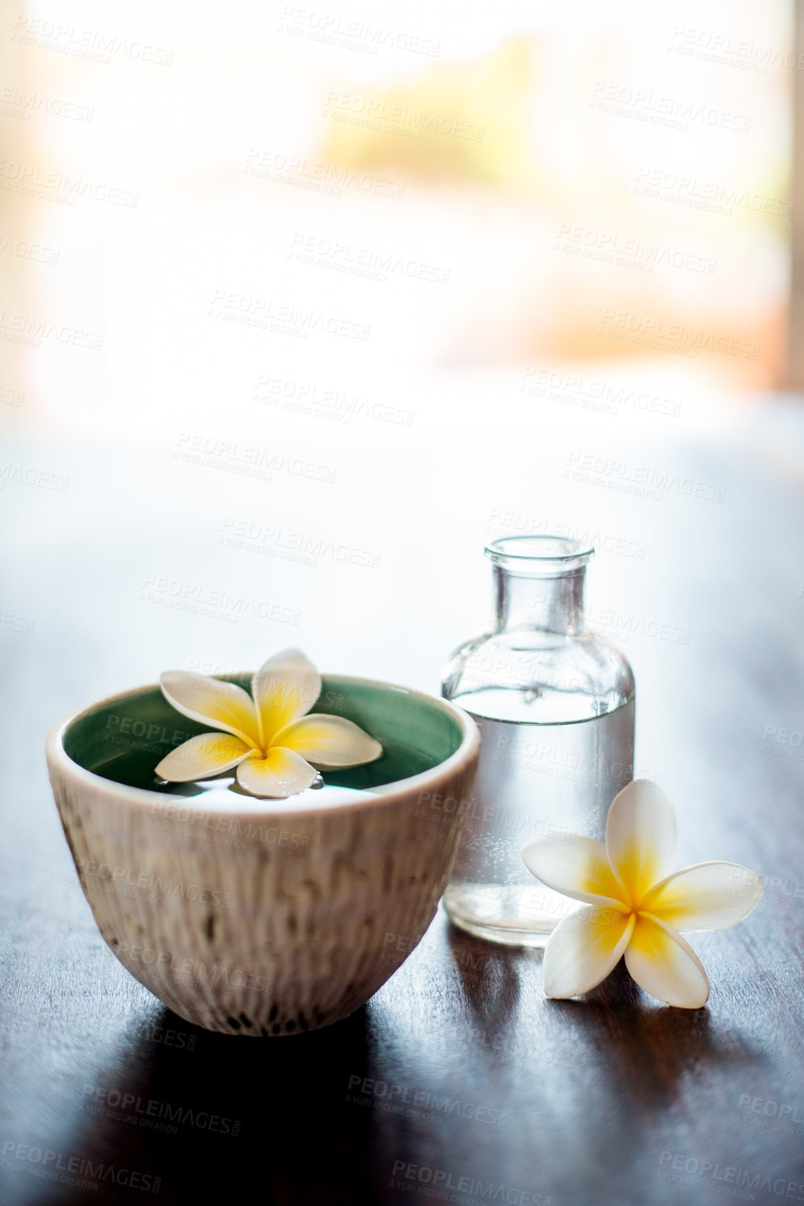 Buy stock photo Flower, spa and essential oil on table with peace, natural product and bowl for fragrance. Holistic health, hospitality service and counter with aromatherapy for self care at luxury wellness salon