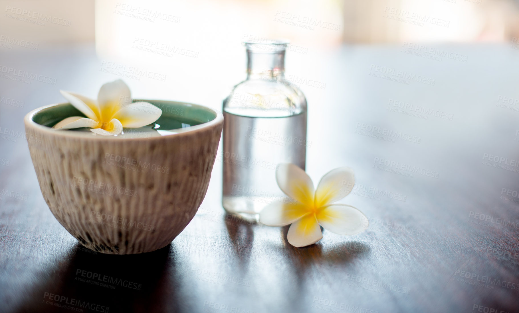 Buy stock photo Flower, spa and essential oil on table with space, natural product and bowl for fragrance. Holistic health, hospitality service and peace with aromatherapy for self care at luxury wellness salon