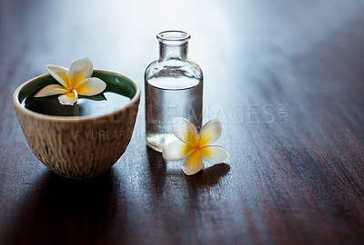 Buy stock photo Flower, spa and essential oil on table with natural product, water and bowl for fragrance. Holistic health, hospitality service and mockup space for aromatherapy, self care and luxury wellness salon