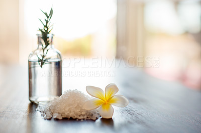 Buy stock photo Table, spa salt and essential oil with flowers for aromatherapy massage, luxury treatment or relaxation. Interior space, hospitality and empty room with organic decoration and natural arrangement