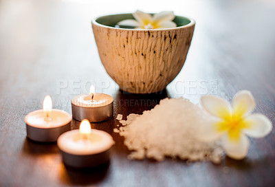 Buy stock photo Wellness, spa candles or salt with flowers on table for aromatherapy treatment, self care retreat or tranquil setup. Interior space, health clinic or empty room with organic product for stress relief