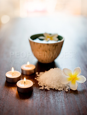 Buy stock photo Cosmetics, spa candles or salt with flowers on table for aromatherapy treatment, self care retreat or tranquil setup. Interior, health clinic or empty room with organic product for hospitality or zen