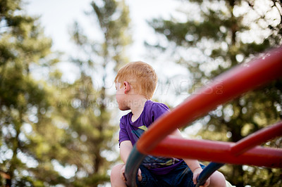 Buy stock photo Children, merry go round and thinking with boy in forest for active play, development or growth. Adventure, balance and carousel with ginger kid having fun on playground equipment in nature 