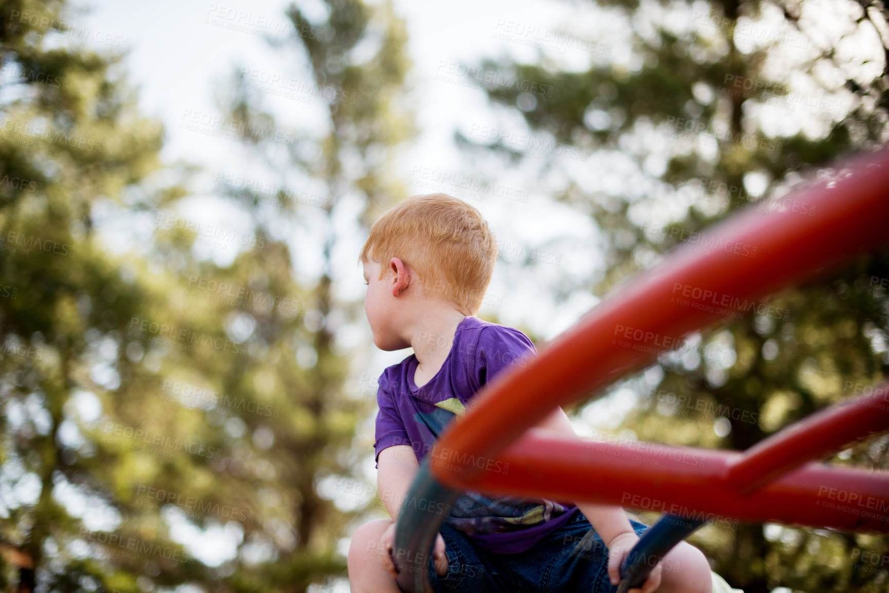 Buy stock photo Children, merry go round and thinking with boy in forest for active play, development or growth. Adventure, balance and carousel with ginger kid having fun on playground equipment in nature 