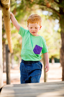 Buy stock photo Boy, child and walking with step in playground for fun childhood, activity or holiday at play park. Little kid, ginger or youth with helping rail for toddler safety, care or playful weekend in nature