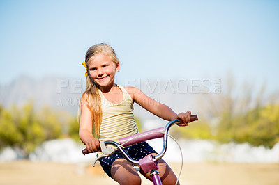 Buy stock photo Girl, child and outdoor for riding bike, learning development and practice in neighborhood. Happy, bicycle and female person for travel adventure on weekend, kid smile and holiday for childhood play
