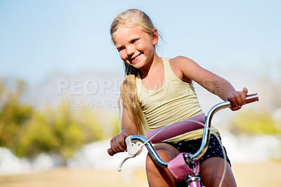 Buy stock photo Girl, child and outdoor for riding bicycle, learning development and practice in neighborhood. Happy, bike and female person for travel adventure on weekend, kid smile and holiday for childhood play
