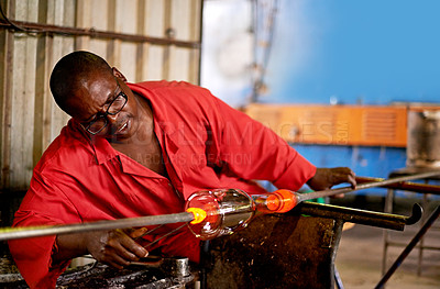 Buy stock photo Glass, blowing and black man in art workshop for small business with heat, tools or technique. Creative, handmade product or glassblower in factory for sustainable process, design or bottle sculpture