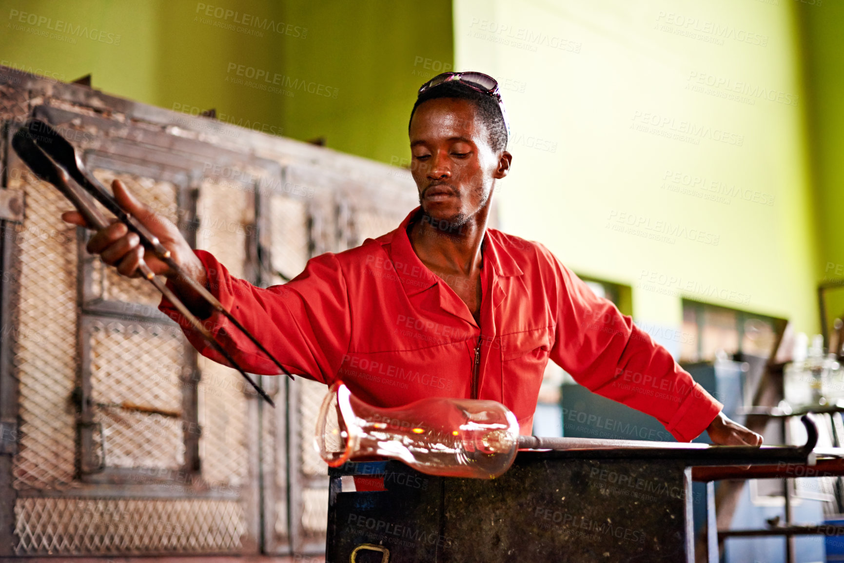 Buy stock photo Glass, art and black man in workshop with tools for small business, craft or handmade technique. Creative, product shape or glassblower in factory for sustainable process, design or bottle sculpture