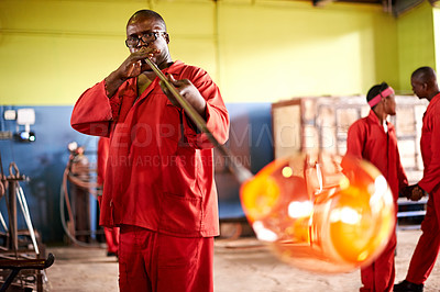 Buy stock photo Glassblowing, glass and man with blowpipe, creative and serious for manufacturing of art and industry. Production, shaping and black people in uniform for craft, glassmakers and design for product