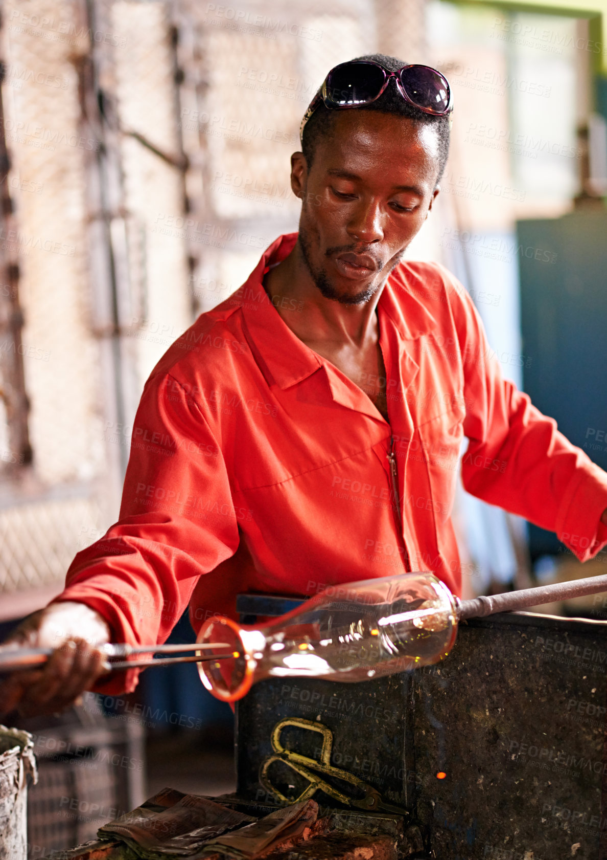Buy stock photo Shot of a glassblower making a glass product in a factory