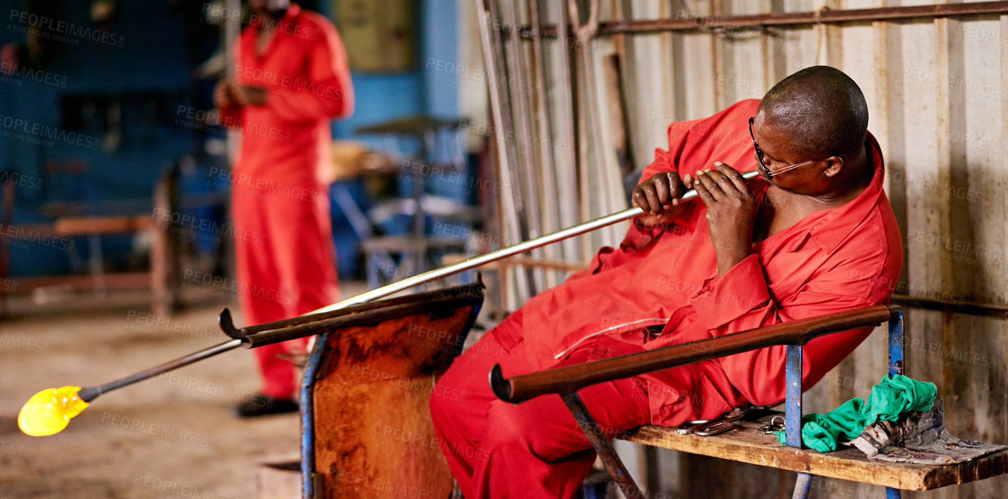 Buy stock photo Glassblowing, heat and shape with black man artisan in forge or foundry for industrial production. Artistic, creative and design with professional glassblower in plant or workshop for manufacturing