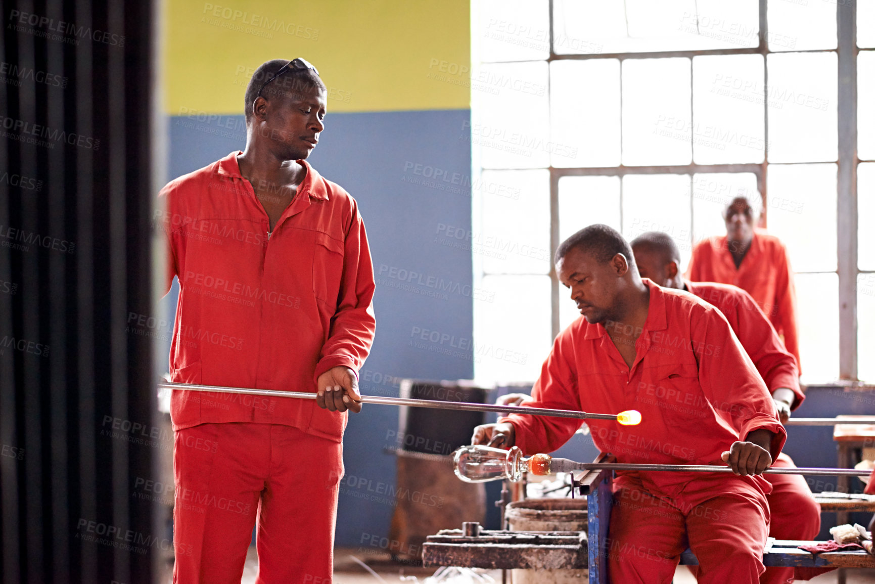 Buy stock photo Men, worker and glassblower in glass factory for manufacturing, production process and industry. Glassware, craft and tools to shape for art, recycling and African group with blowpipe for welding
