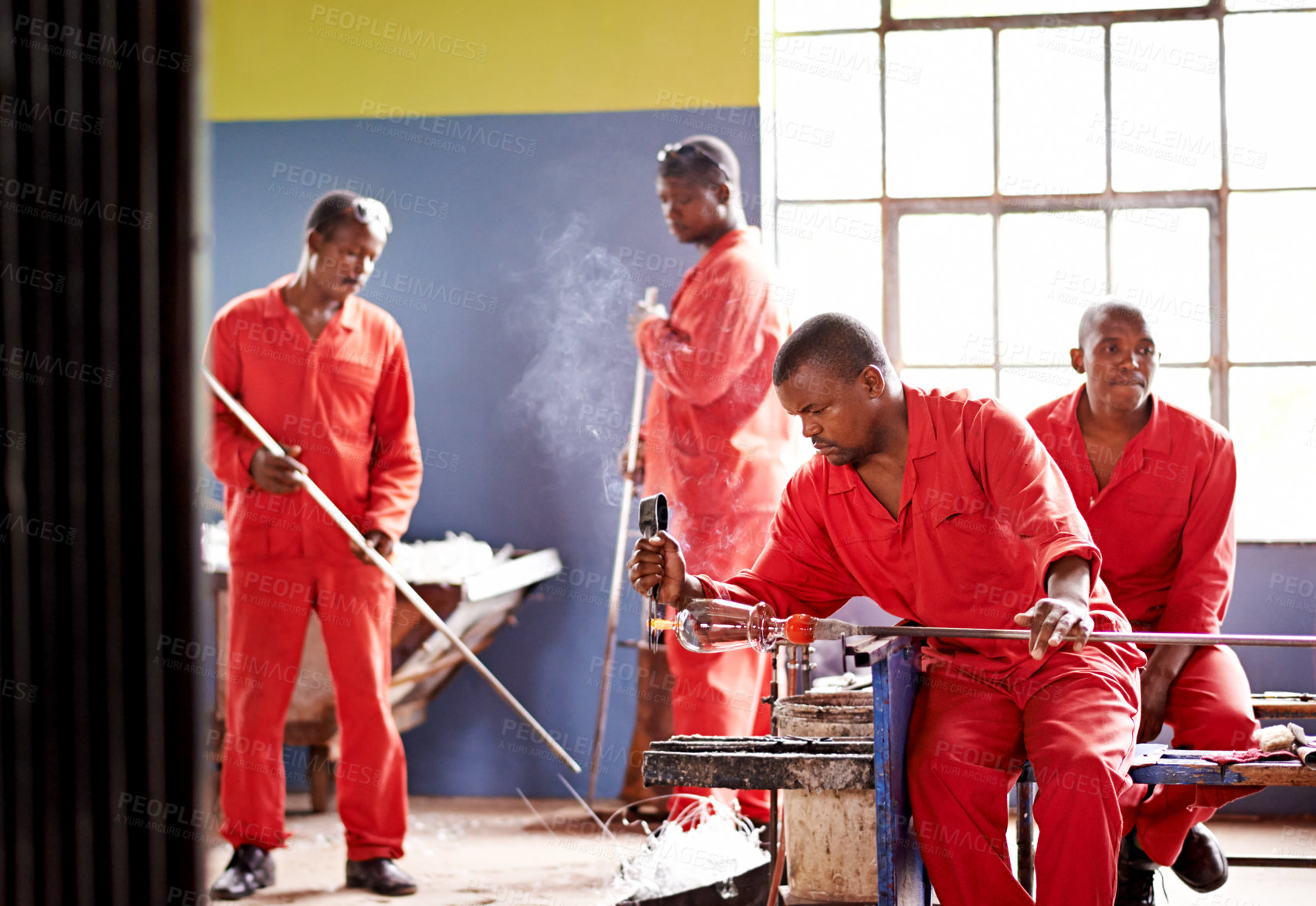 Buy stock photo Glassblower, molding and man in factory with production and equipment for professional craft. Labor, workshop and person shaping object with tools for metalwork, manufacturing and forge for heating