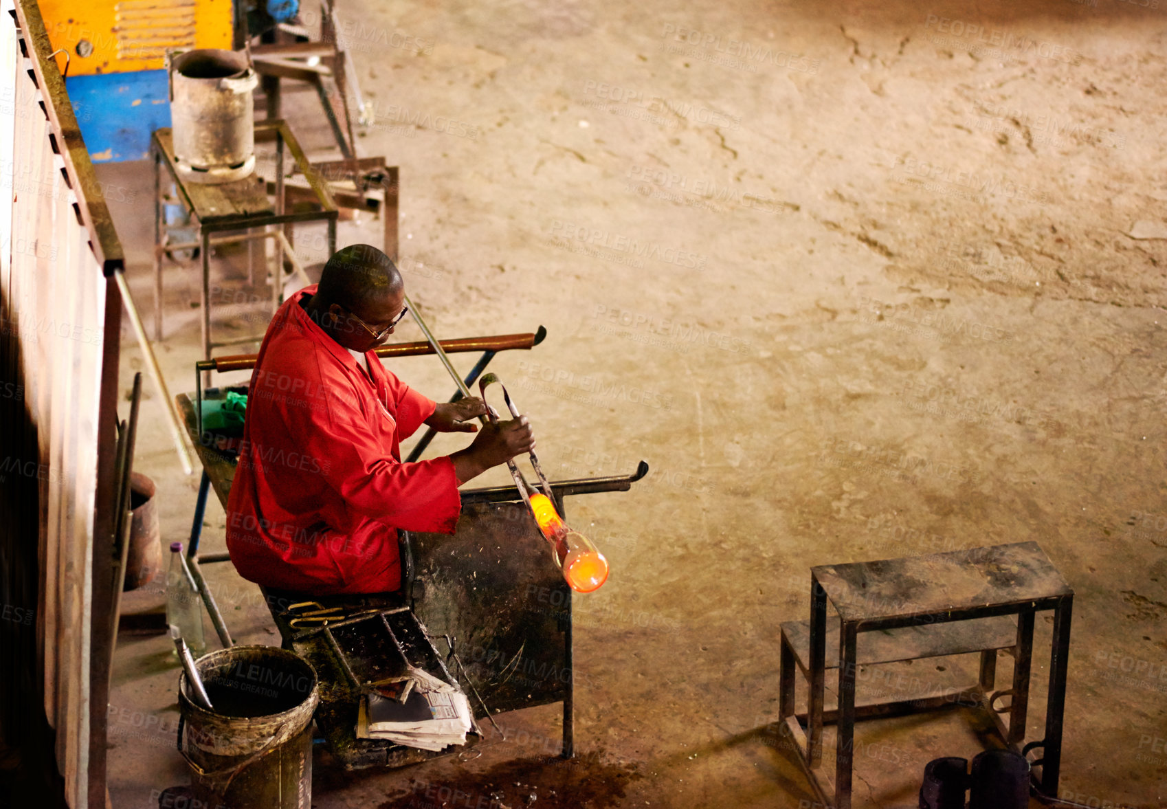 Buy stock photo Above, glassblower and black man with tools, material  and heat with craftsmanship, manufacturing and metal industry. Person, technique or employee in workshop, productivity or process with equipment