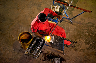 Buy stock photo Above, glassblower and man with equipment, skills and heat with craftsmanship, material and talent. Person, technique and employee in factory, manufacturing and tools with productivity and industry