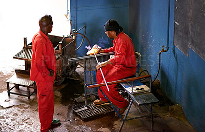 Buy stock photo Glassblowers, industry or people in workshop with heating equipment, professional craft or production. Labor, factory or team of men molding object with tools for metalwork, manufacturing and shape