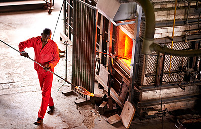 Buy stock photo Above, glassblower and black man in factory, furnace and equipment with tools, heat and industry. African person, technique and employee with material, skills and artistry with manufacturing and iron