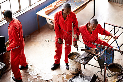 Buy stock photo Glassblowers, fire and people manufacturing vase for equipment, professional craft and production. Industrial, factory or top view of artisan molding object with tools for manual labor or heating