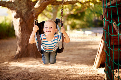 Buy stock photo Happy, swing and portrait of kid in park with play, outdoor adventure and fun child development in nature. Relax, wellness and boy in playground for growth, morning games or playful childhood weekend