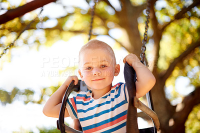 Buy stock photo Fun, swing and portrait of boy in park with trees, outdoor adventure and child development in nature. Play, smile and kid in playground for growth, games or summer childhood on weekend from below