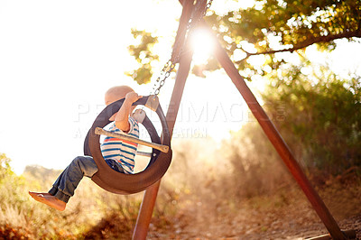 Buy stock photo Tree, swing and boy in park with outdoor adventure, play and development for kids in nature. Sunshine, happy and child in playground for growth, fun games and summer childhood on playful weekend