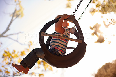 Buy stock photo Tree, tyre swing and child in park with fun, outdoor adventure and playful development for kids in nature. Relax, weekend and boy in garden playground for games, childhood and summer energy with sky