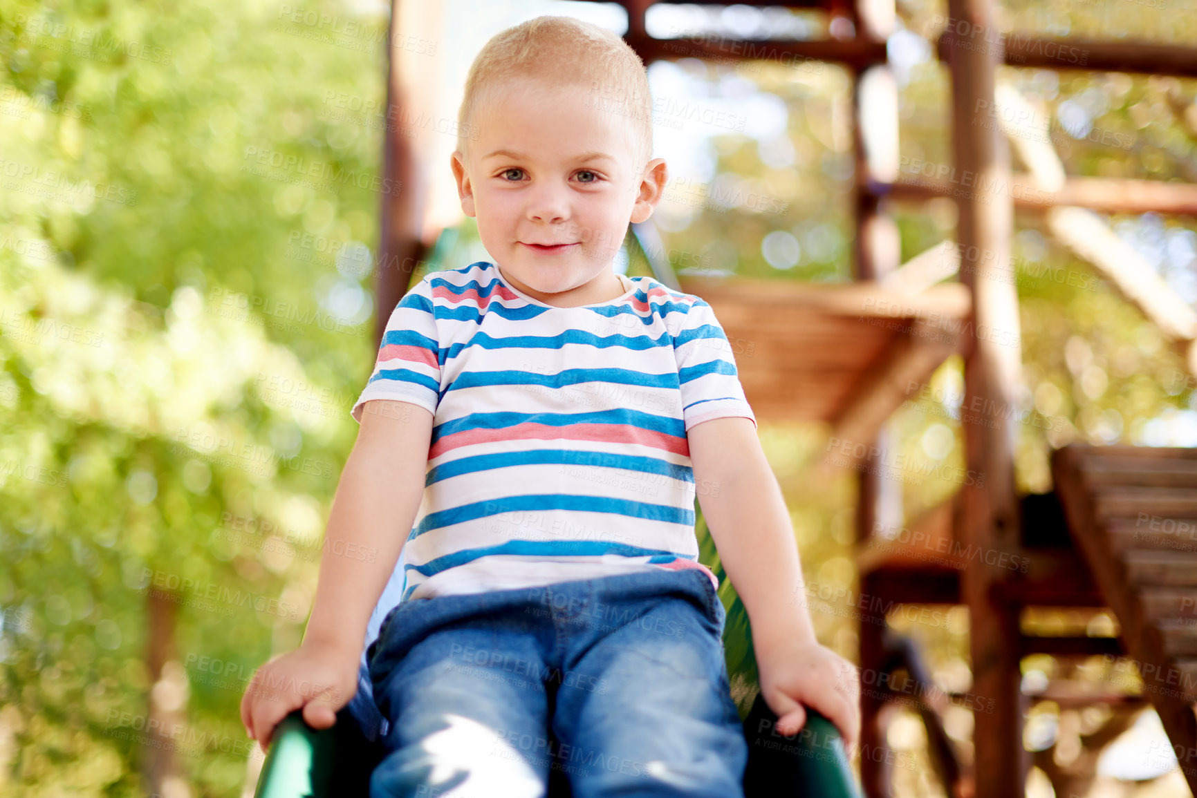 Buy stock photo Happy, playing and portrait of kid on slide in park for physical skills, confidence or fun. Exploring, nature and boy child on playground equipment for adventure, hobby or cognitive development.