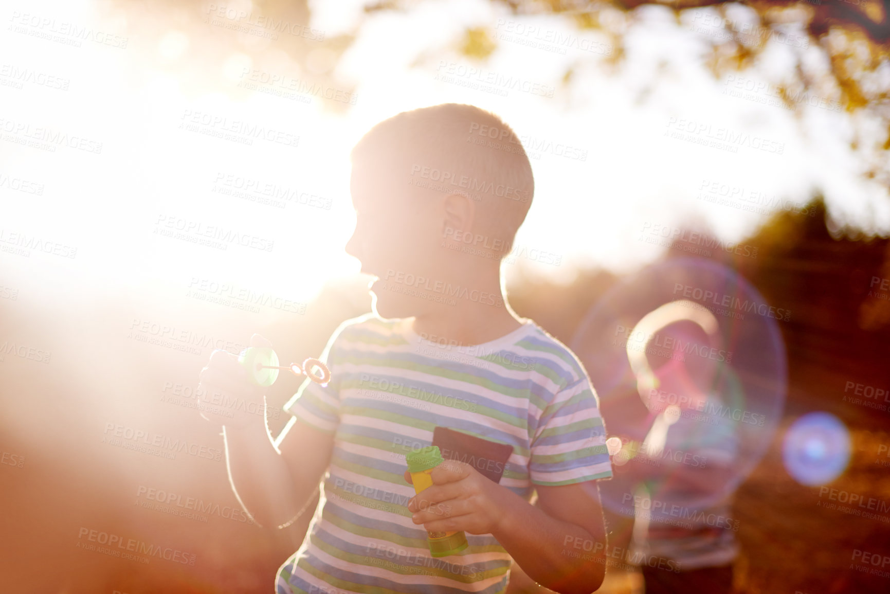 Buy stock photo Sunlight, blowing bubbles and children in nature for fun, childhood and bonding together outdoors. Family, happy and young brothers with soap, toys and activity for playing, adventure or game in park