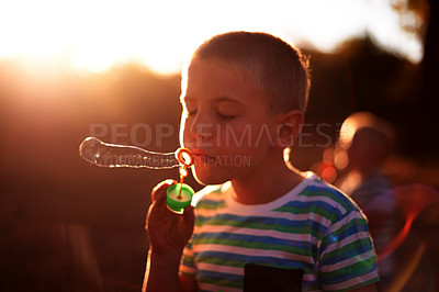 Buy stock photo Bubbles, blowing and child in park with fun, sunset adventure and outdoor development for kids in nature. Relax, weekend and boy in garden playground with soap wand, childhood games and play activity