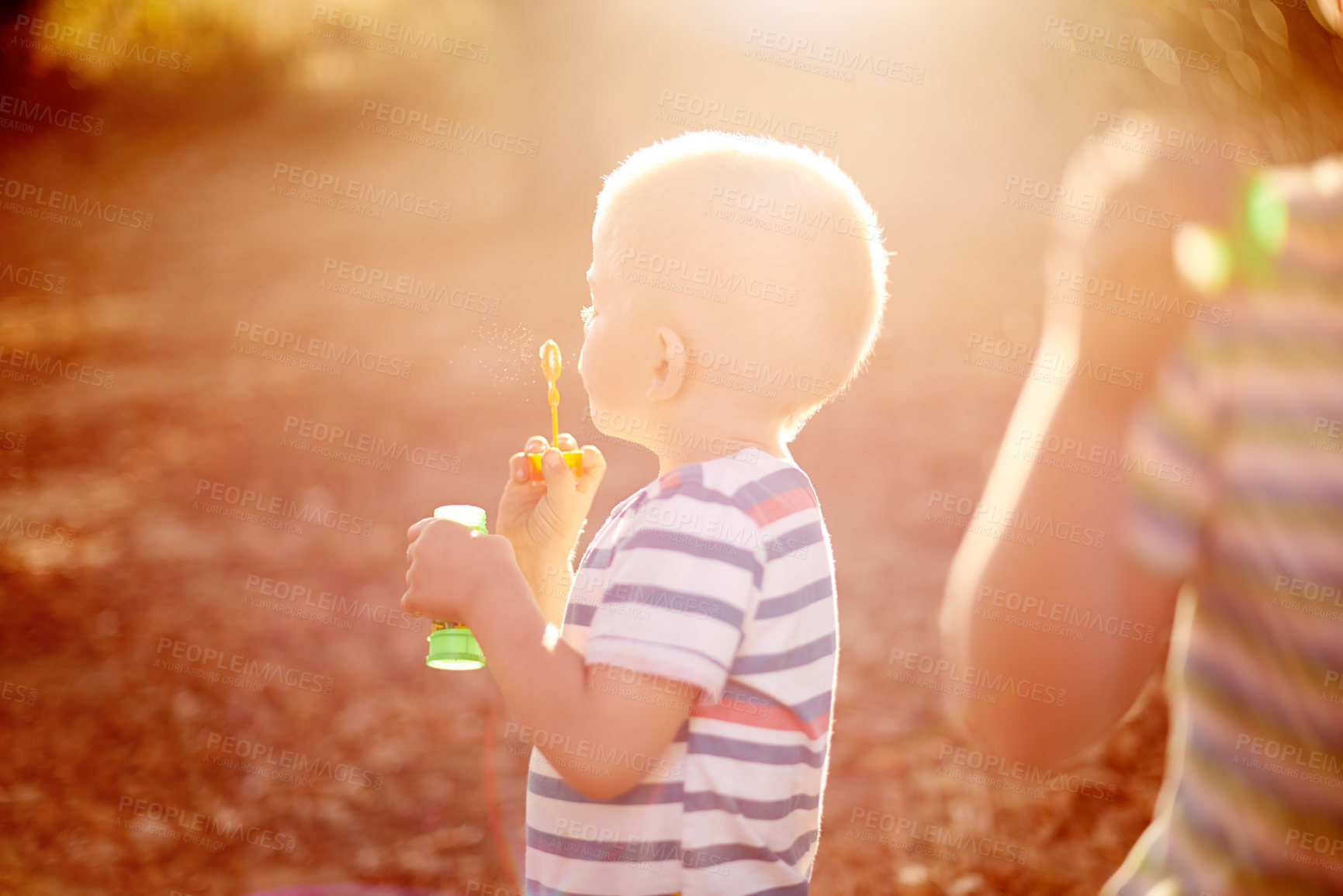 Buy stock photo Sunshine, blowing bubbles and child in nature for fun, childhood and bonding together outdoors. Family, backyard and young brothers with soap, toys and activity for playing, adventure or game in park