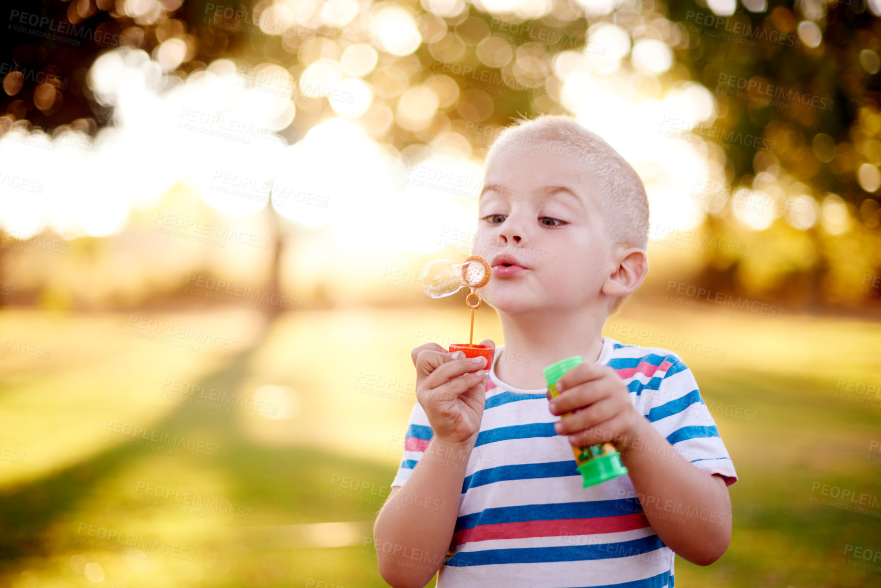 Buy stock photo Boy, kid or blowing bubble with wand in nature for playful weekend, childhood or fun summer at outdoor park. Little child, toddler or youth with magic stick, vision or dream for fantasy on playground