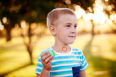 Buy stock photo Boy, child or blowing bubble with wand in nature for playful weekend, childhood or fun summer at outdoor park. Little kid, toddler or youth with magic stick, vision or dream for fantasy on playground