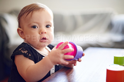 Buy stock photo Home, baby and portrait with toys for development, playing and motor skills for stack. House, girl and child with plastic cups for sensory interaction, learning and curiosity with cognitive growth