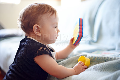 Buy stock photo Baby, profile and toys in home for play, sensory development and foam book for growth. Girl toddler, fidgeting and blanket on sofa for stimulation, creative engagement and motor skills in living room
