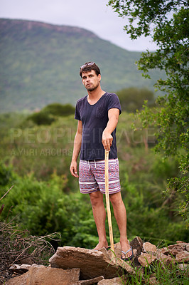 Buy stock photo Portrait, man and hiking in nature with stick for travel, adventure and holiday trip in countryside. Serious, trekking and person in forest for tourism, vacation journey or exploration in Switzerland