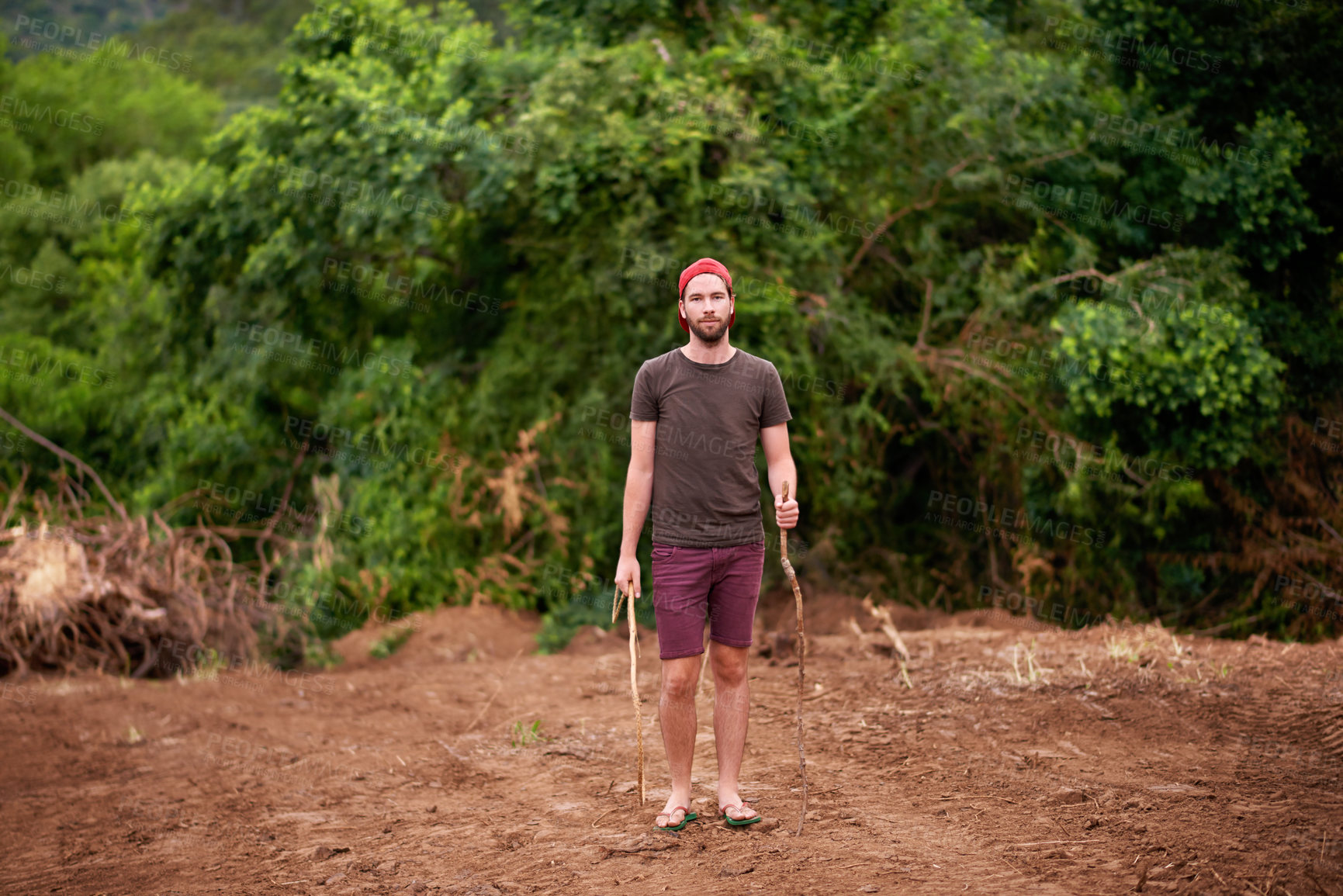 Buy stock photo Portrait, man and hiking outdoor with stick for travel, adventure and holiday trip in countryside. Serious, trekking and person in forest for tourism, vacation journey and exploration in Portugal