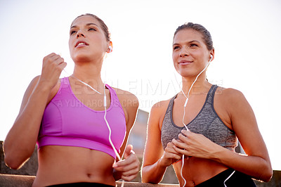 Buy stock photo Earphones, fitness and sisters in city for running with marathon training with music or podcast. Thinking, sports and women twins with audio tech for cardio workout or exercise on bridge in town.