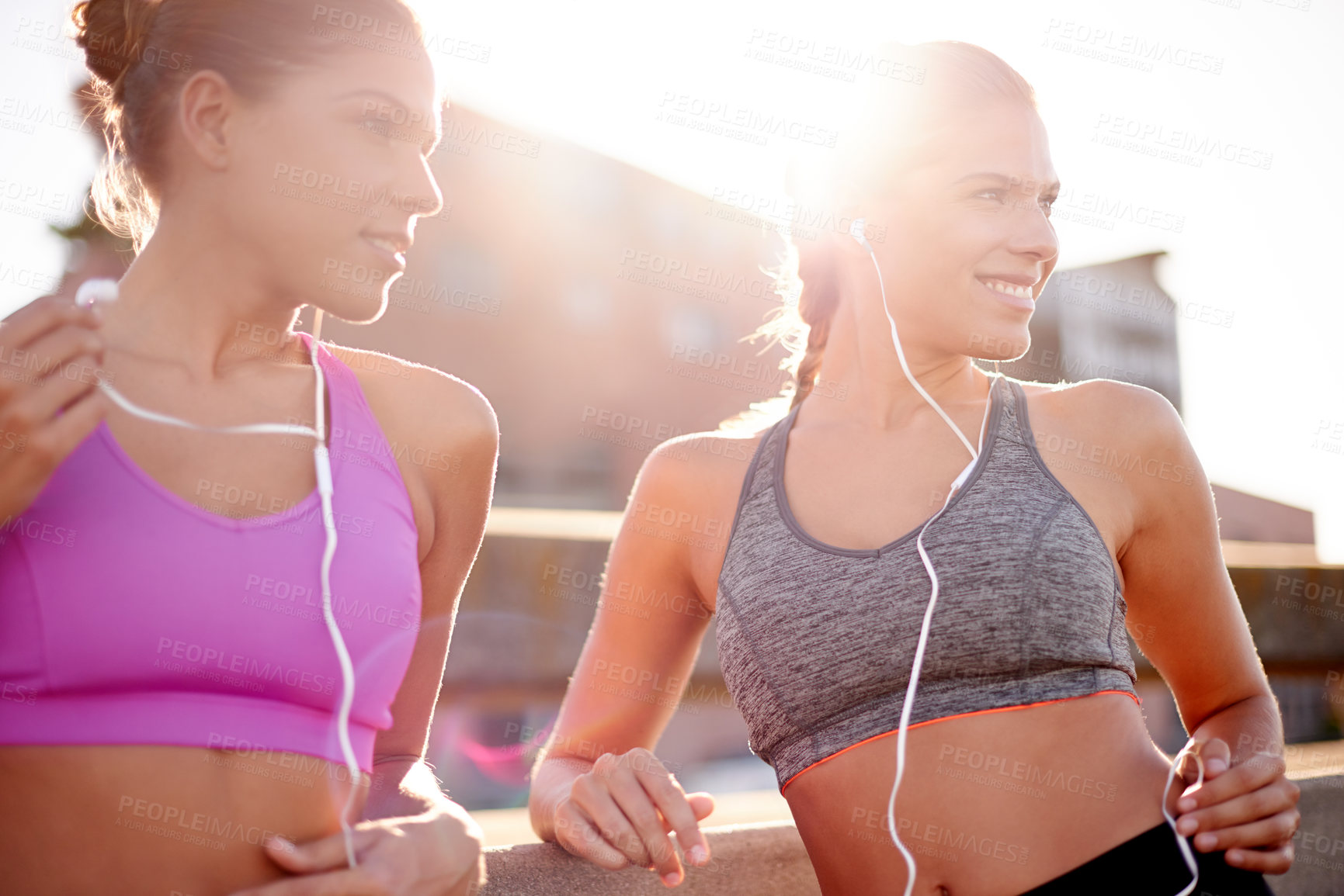 Buy stock photo Earphones, fitness and sisters in city thinking for running route with marathon training with music. Happy, sports and women twins with audio tech for cardio workout or exercise on bridge in town.